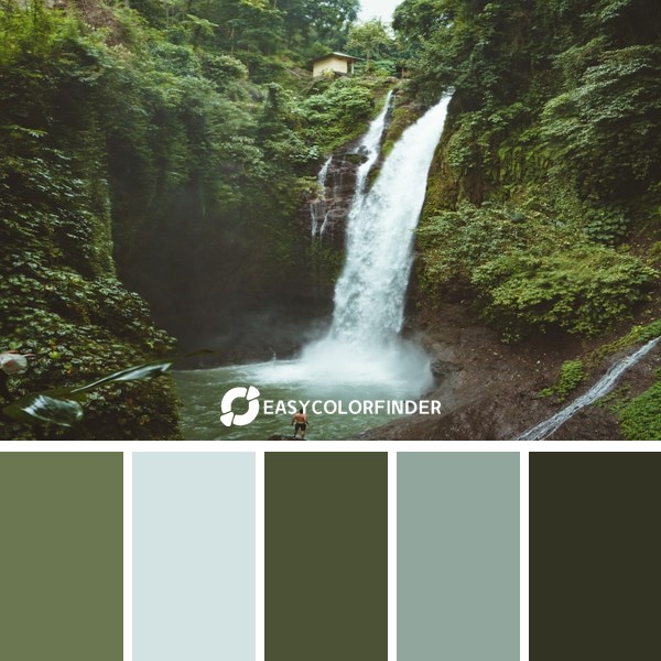 man standing on top of rock near waterfalls