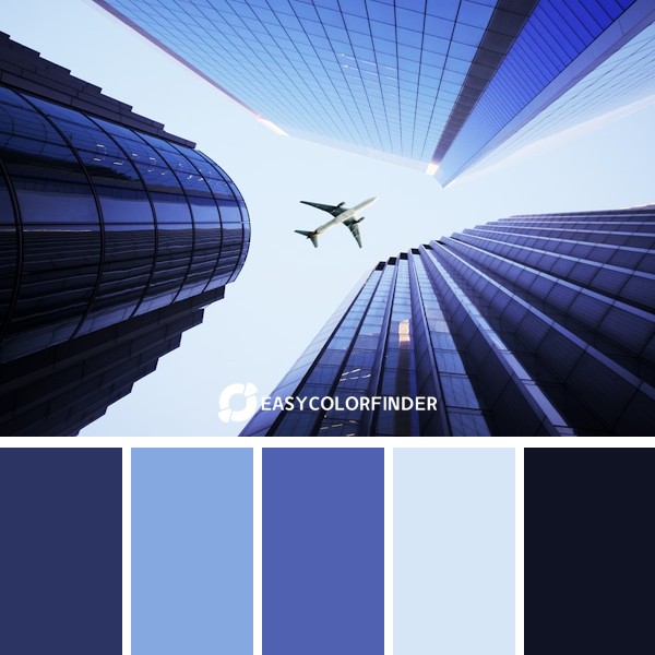 white airplane flying over the high rise building during daytime